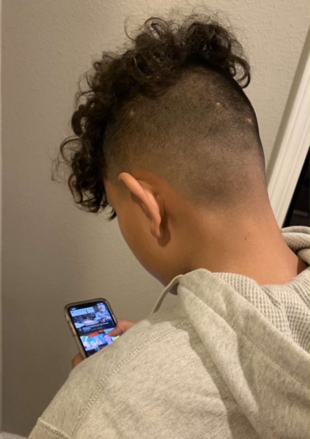 My 14 year old cousin using his iPhone 11  scrolling through YouTube searching for a video to watch.