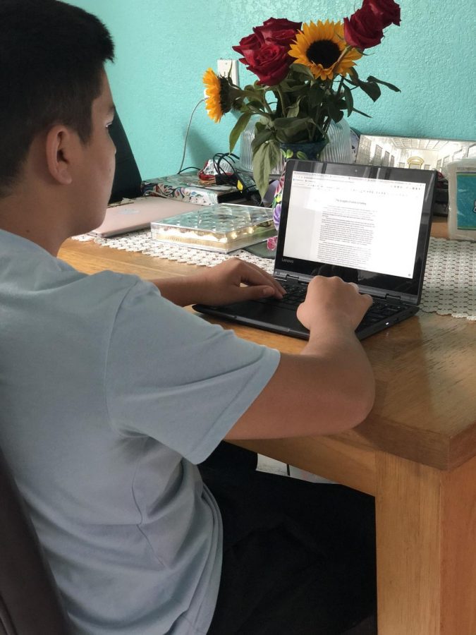 Journalist Arih Mendez doing schoolwork in the kitchen due to space limitations in his bedroom.