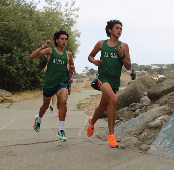 At Natividad Creek Park in the Salinas City Championships, sophomore Fernando Herrera passes senior Erik Luna, entering the second mile of the course. The varsity boys placed first, winning back to back City Championships, and their fifth in seven years. “I was feeling good, the warm up felt really good, coach [Munoz] told me to run a 5:25 [per mile average],¨ Herrera said. 
