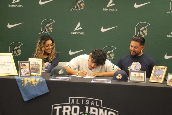 Flanked by his mother and father, senior Xavier Mendez signs his letter of intent to play baseball at Reinhardt University on November 15, 2023.
