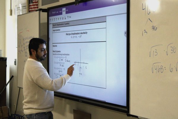 In his period 4 Math 2 class, Mr. Rocha goes over the bell ringer with his students giving them their opportunity to check their answers. 