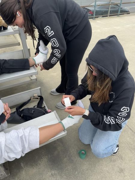 Right before a track meet against Salinas high, Student Athletic trainers Rebecca Jimenez and Kristine Saldo tape the ankles of junior Angel Perez and sophomore Flor Amaya to prepare them for their meet. “It's pretty difficult to do the work and if the patient isn't cooperating as well. It’s also harder when they’re more hurt because they tend to be more sensitive when taping, but the process of the taping is to allow them to feel comfort and support on their ankle,”  Jimenez said.

