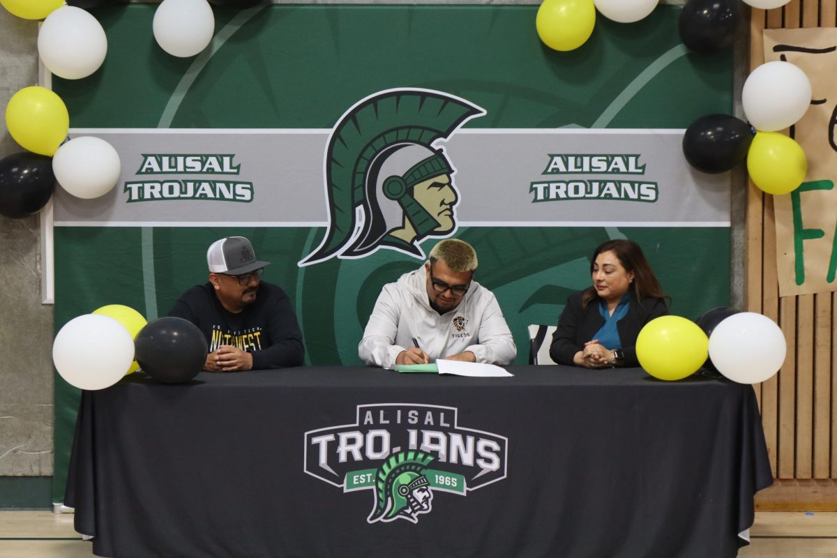 Senior wrestler Fabian Martinez signed his letter of intent with Fort Hay Tech Northwest on March 31, as his dad and mom look on.  
