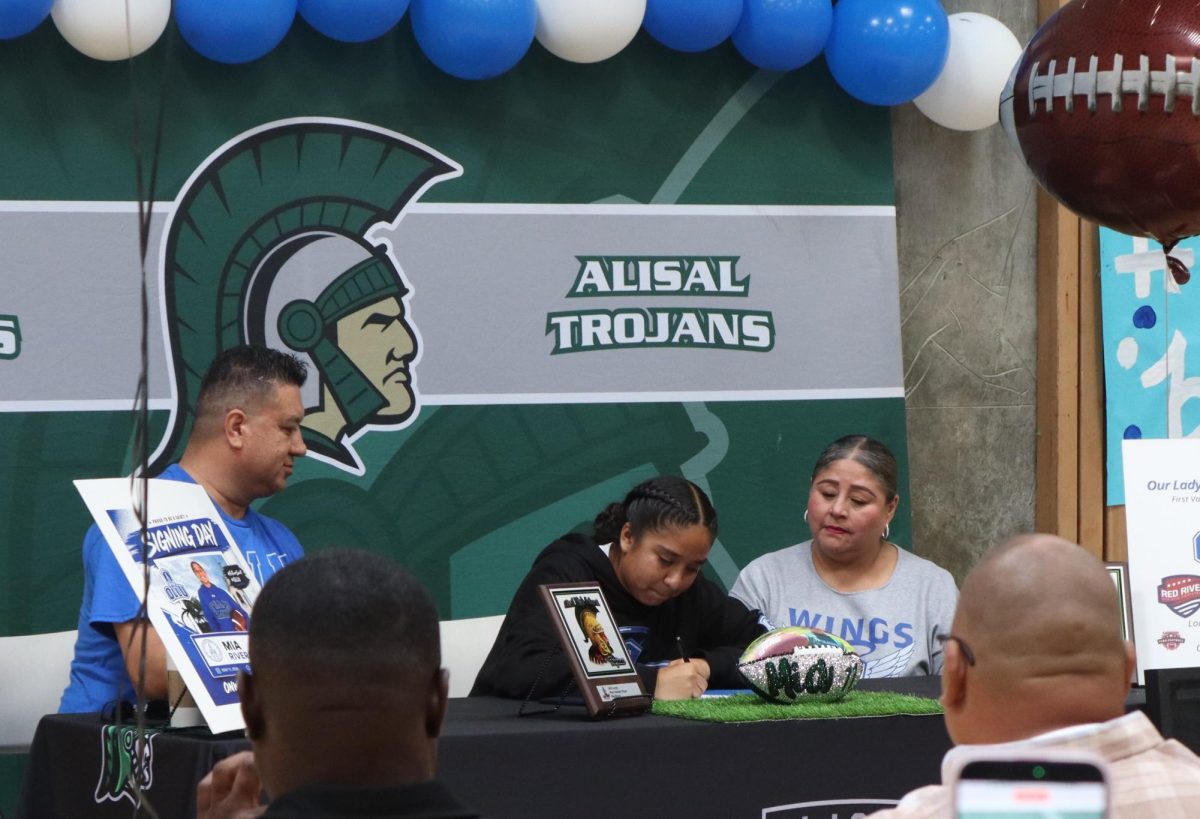 Senior Mia Rivera signs her letter of intent to Our Lady of the Lake University on May 11, with her father and mother, Ernesto and Laura. “I am excited to meet my new teammates, explore Texas, and see how it feels to be on my own,” she said.